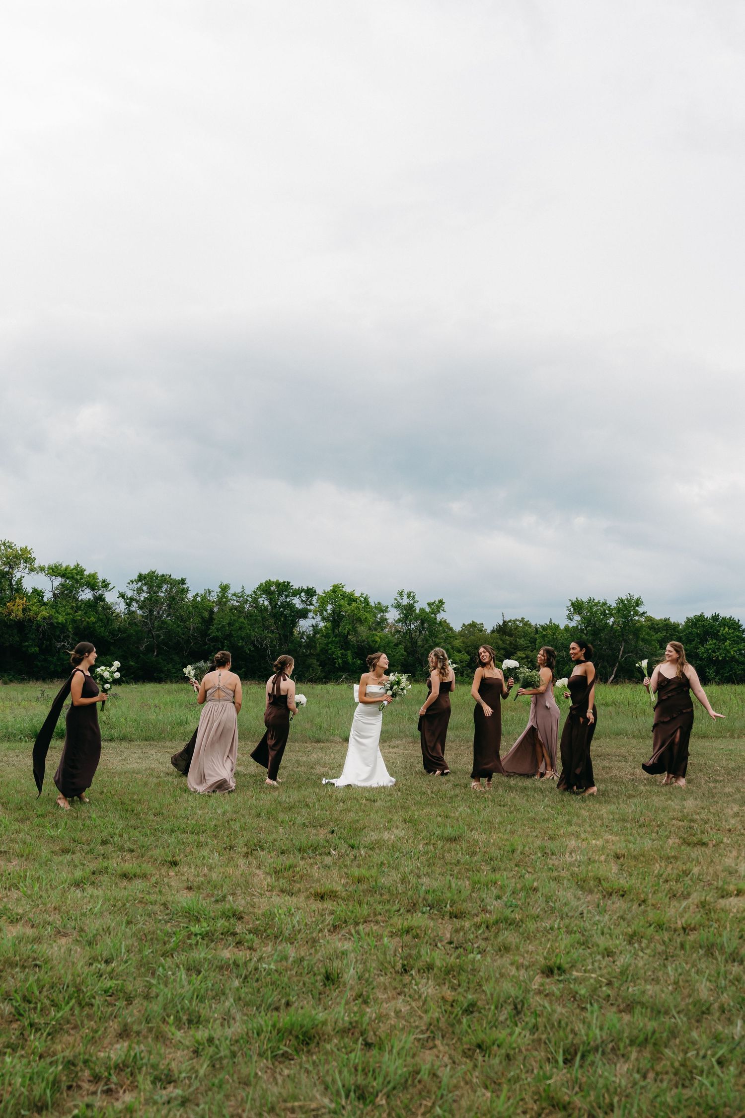 Bride and bridesmaid laughing together while preparing for a wedding ceremony.