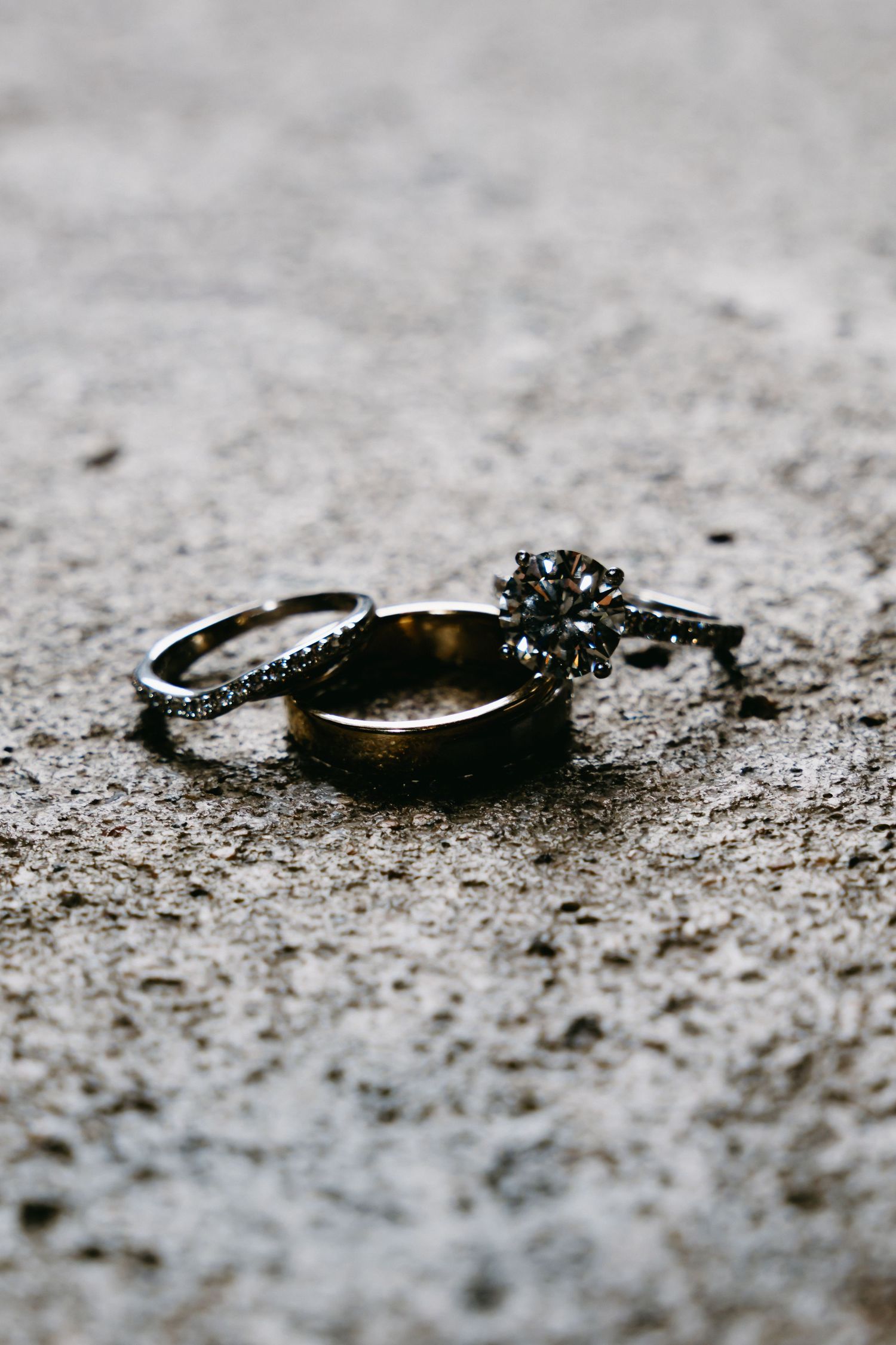 Close-up of wedding rings with shallow depth of field on textured surface.