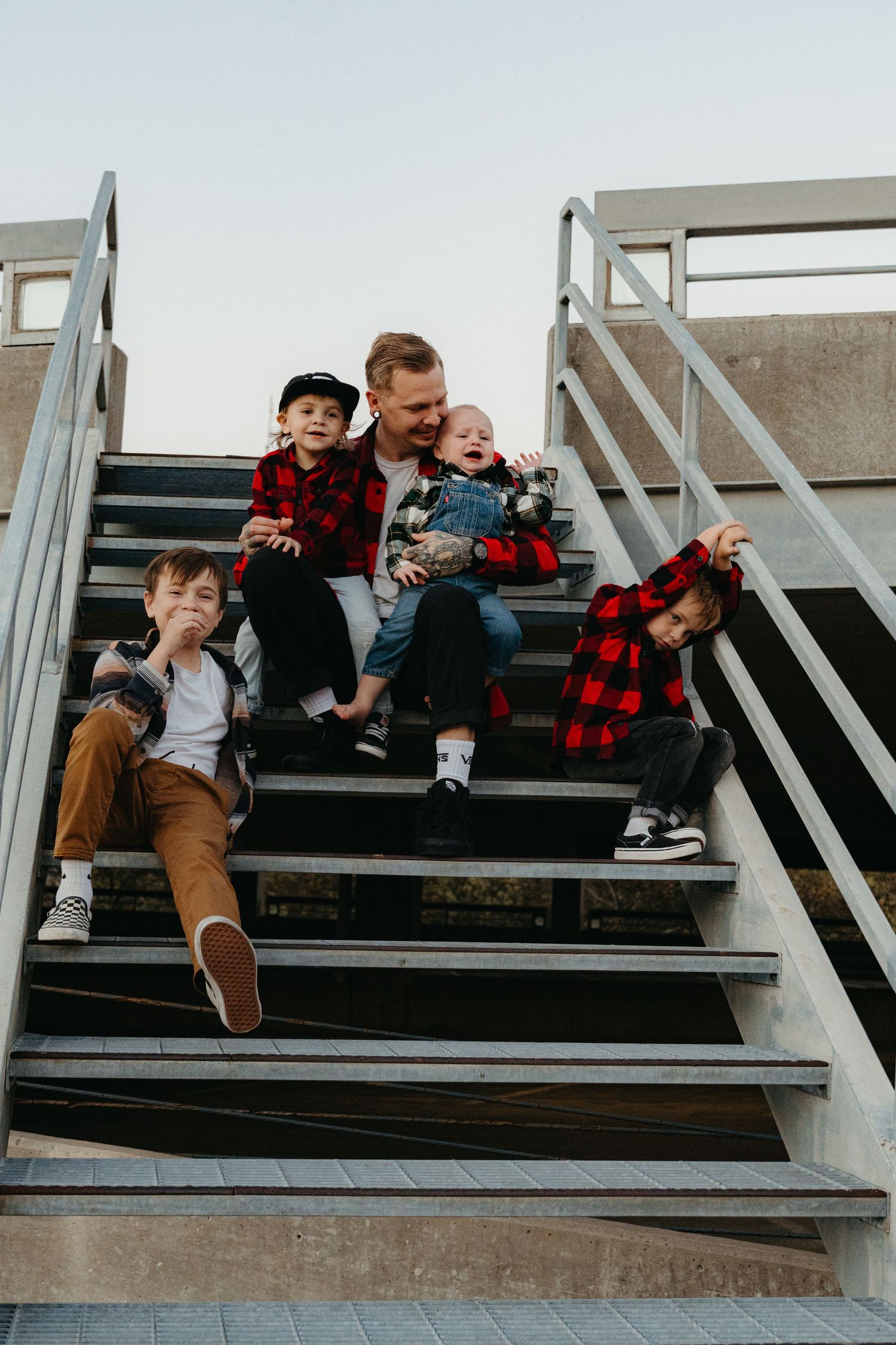 Family sitting together on outdoor concrete steps.