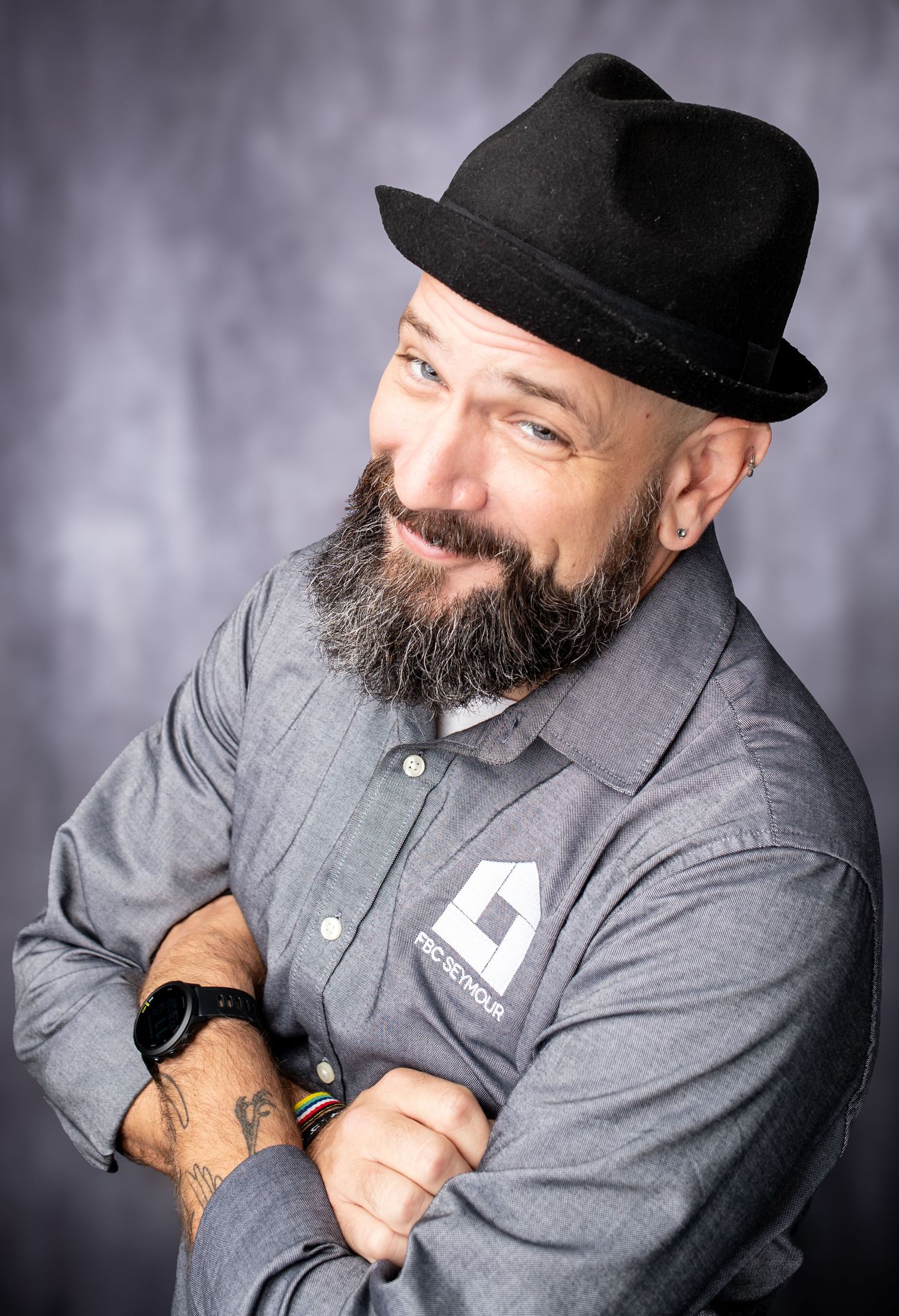 Portrait series showing a person wearing a black hat and gray button-up shirt posing against a dark background.