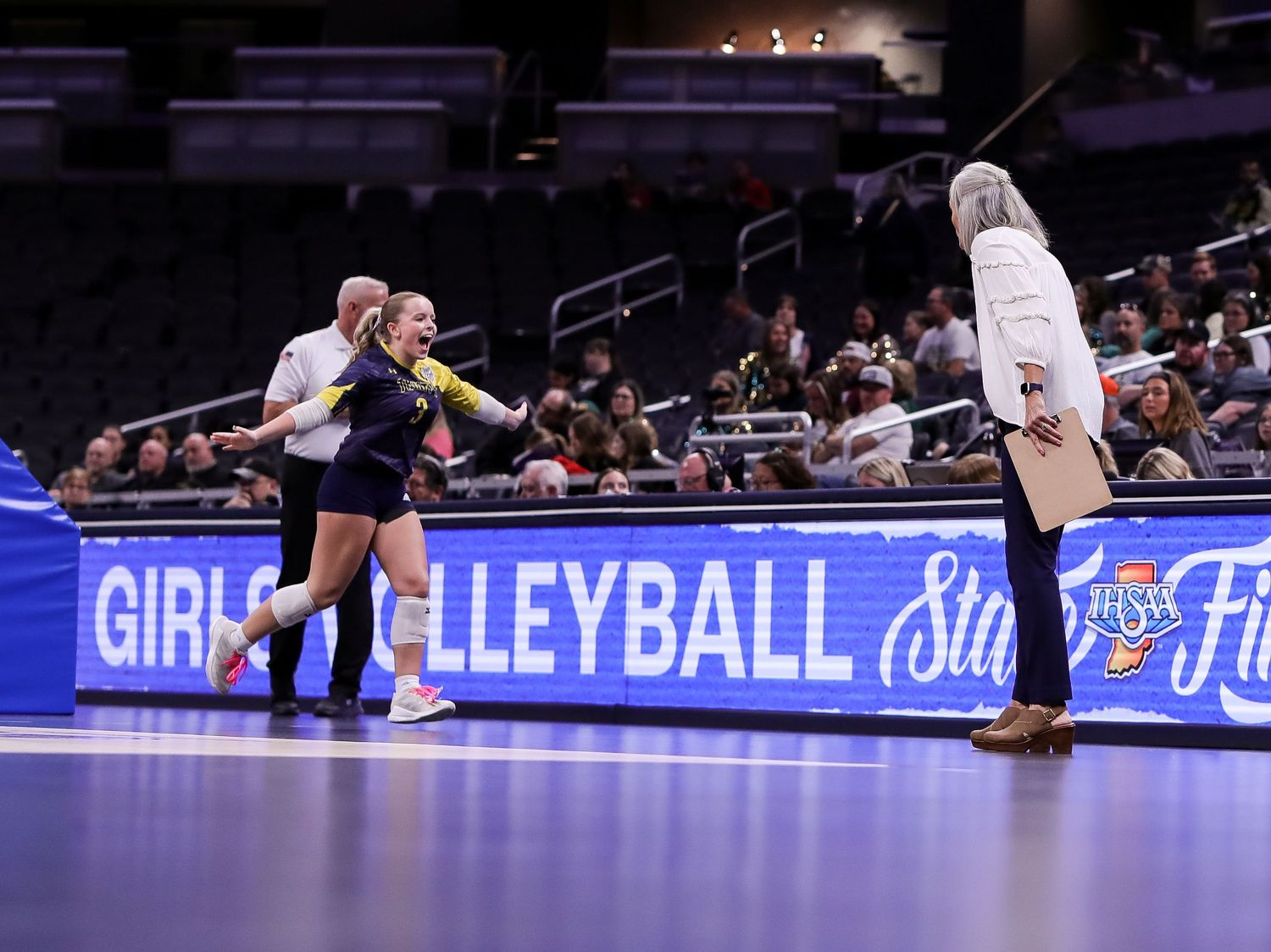 Volleyball player runs with excitement to the bench