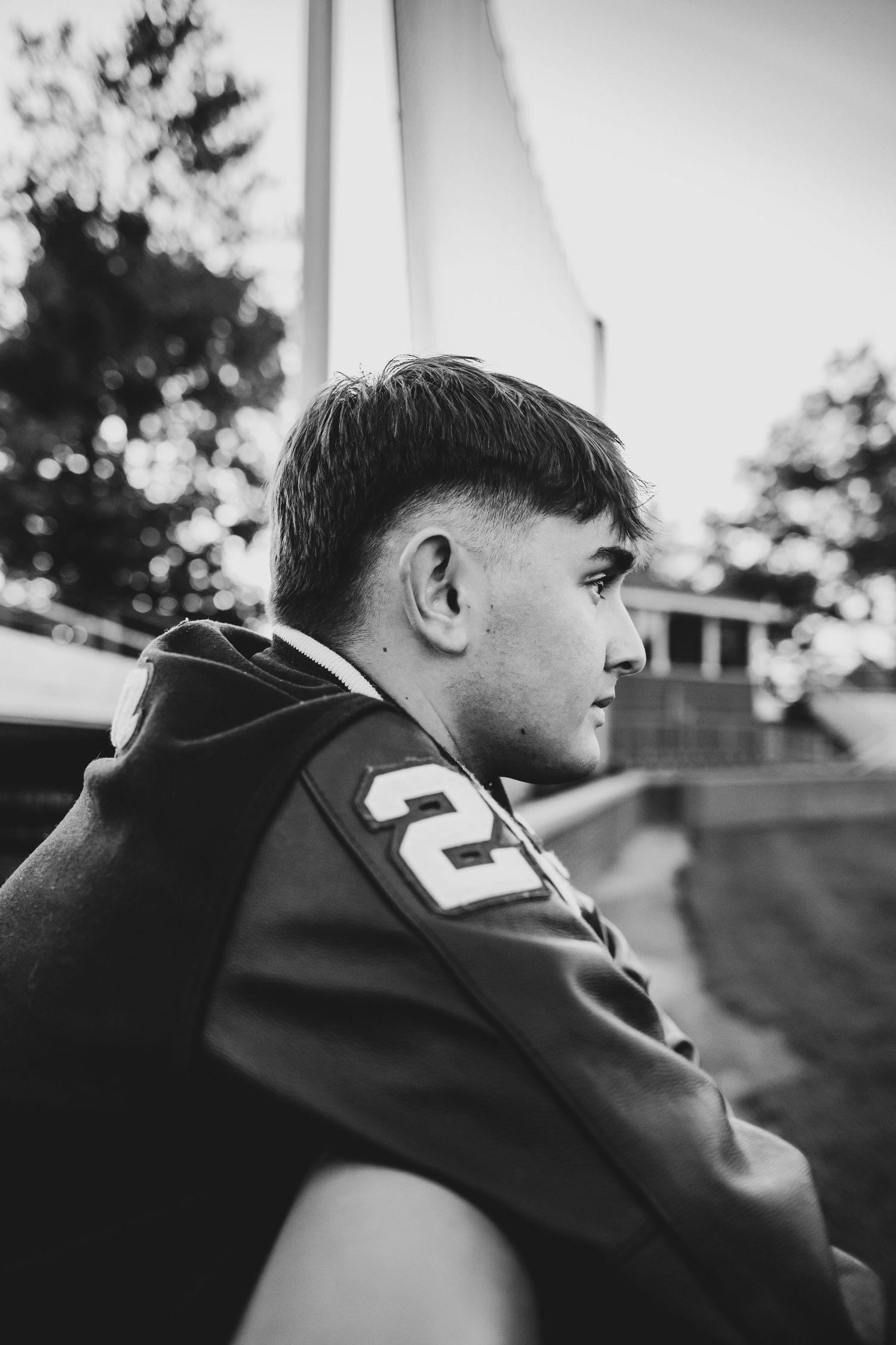 Black and white profile view of a person wearing a sports jersey with number 2 visible in an outdoor setting.