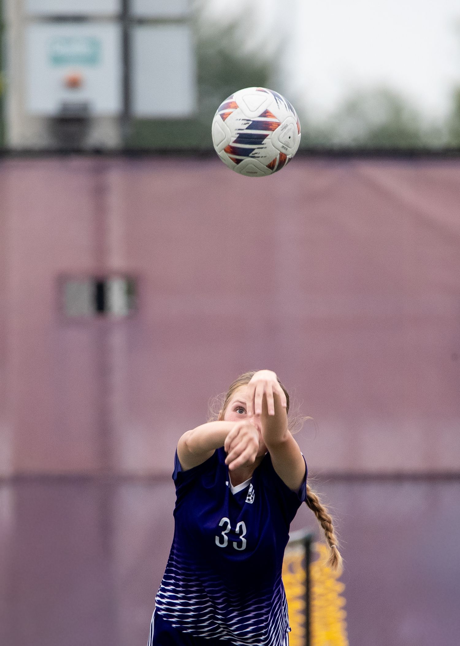 Soccer player in navy blue jersey number 33 throws the ball in during a match.