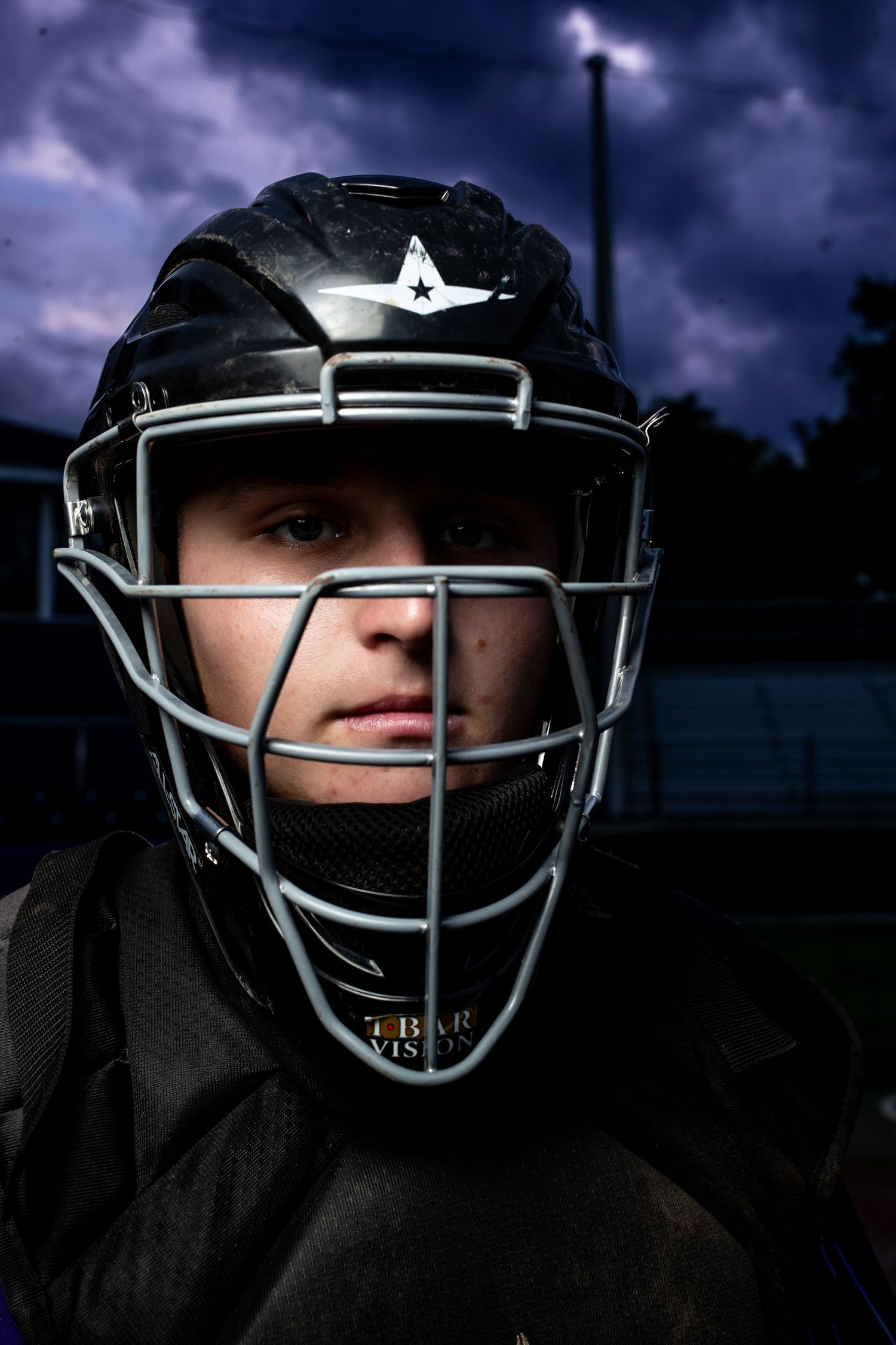 A series of dark moody photographs showing a baseball catcher wearing protective gear against a stormy sky background.