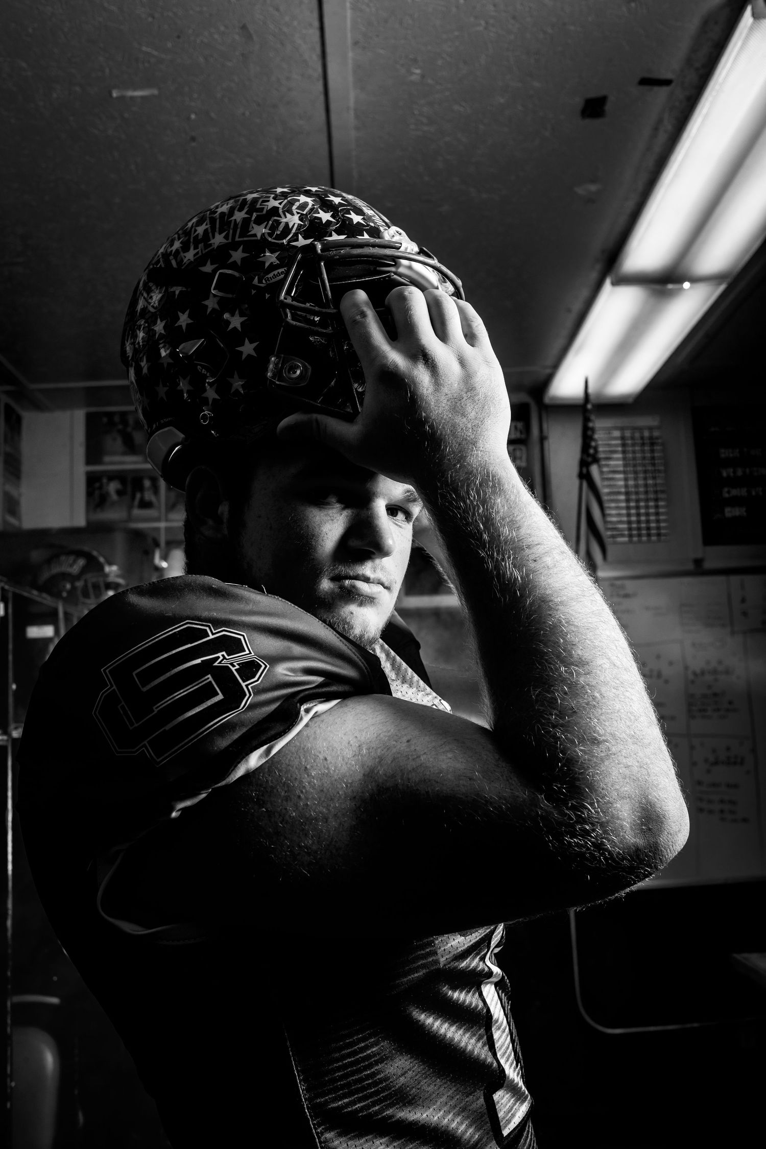 A black and white photo sequence showing a person in shadow putting on their helmet against a dark background.