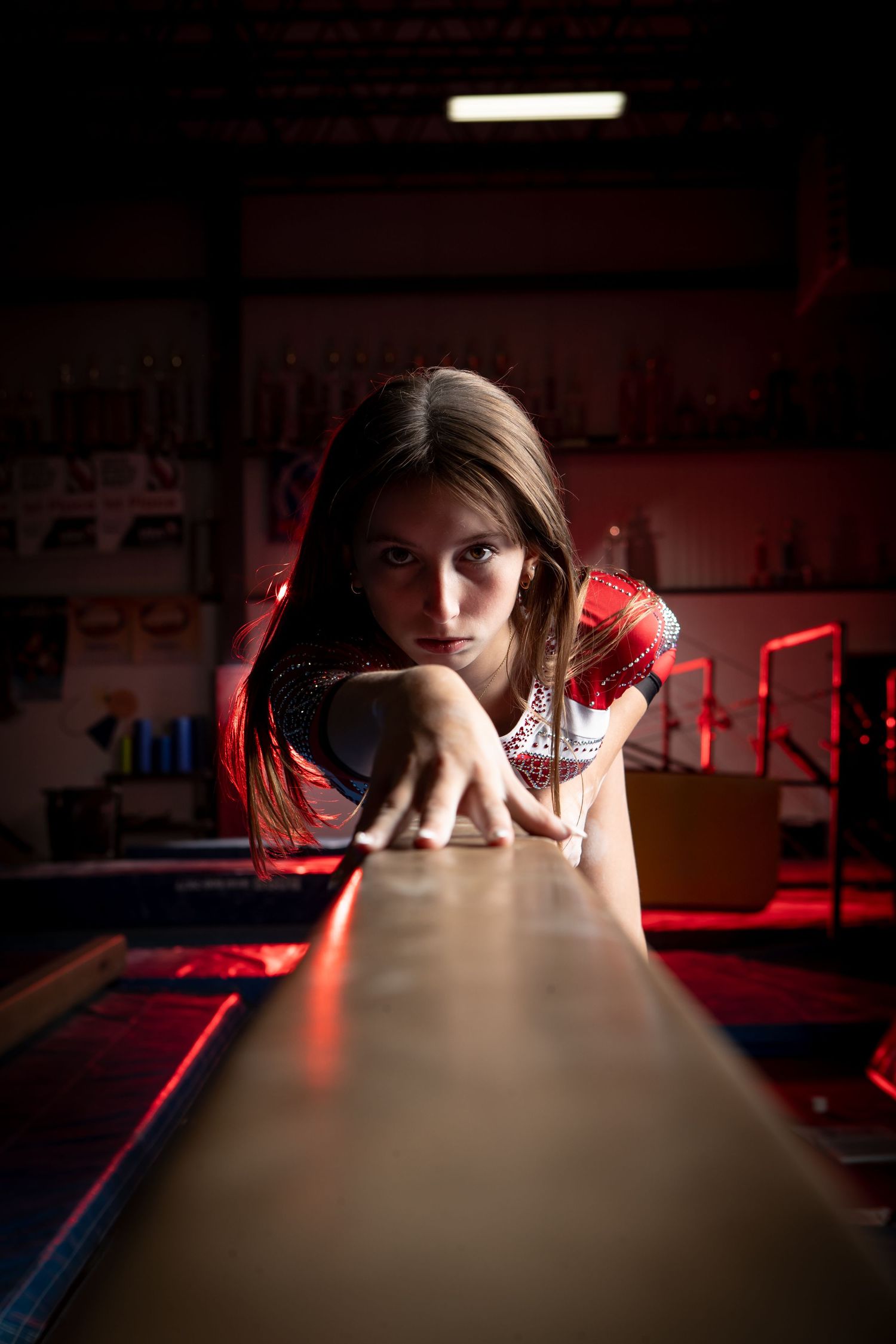A sequence of photos showing a figure resting their head on a dark surface with dramatic red lighting in a gym environment.