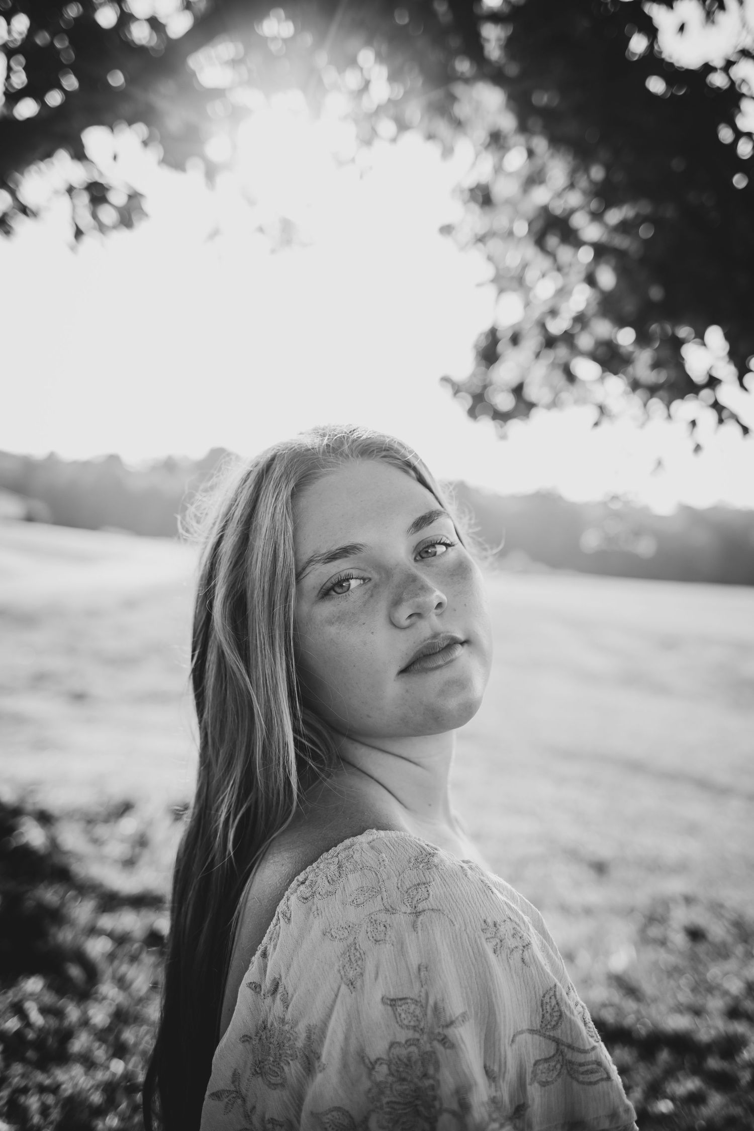 Black and white artistic portrait series showing a person in lace clothing looking up at natural lighting through trees.