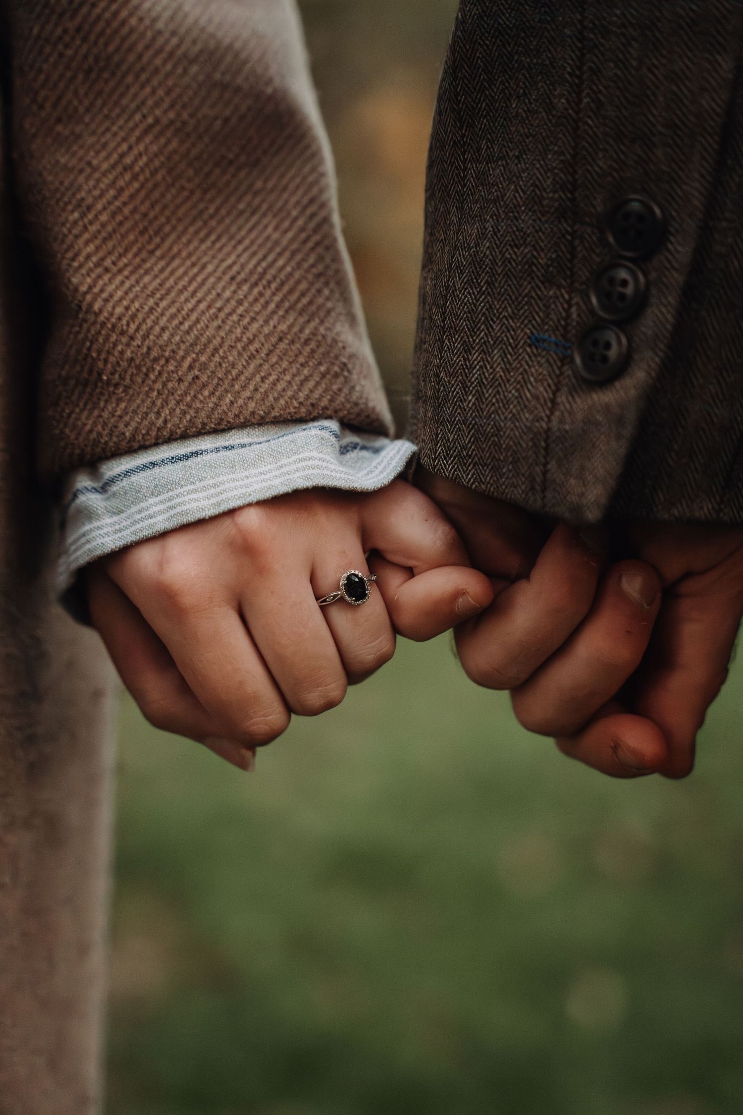 Close-up of hands wearing wedding rings touching tenderly.