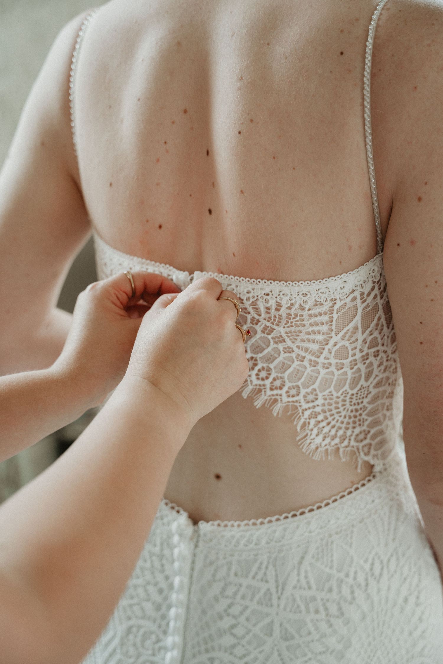 Close-up detail of delicate lace back on white wedding dress.