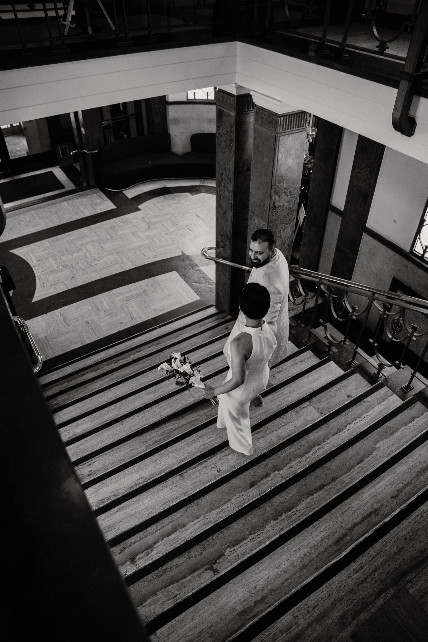 A dramatic black and white photo of stairs casting long shadows in an architectural space.