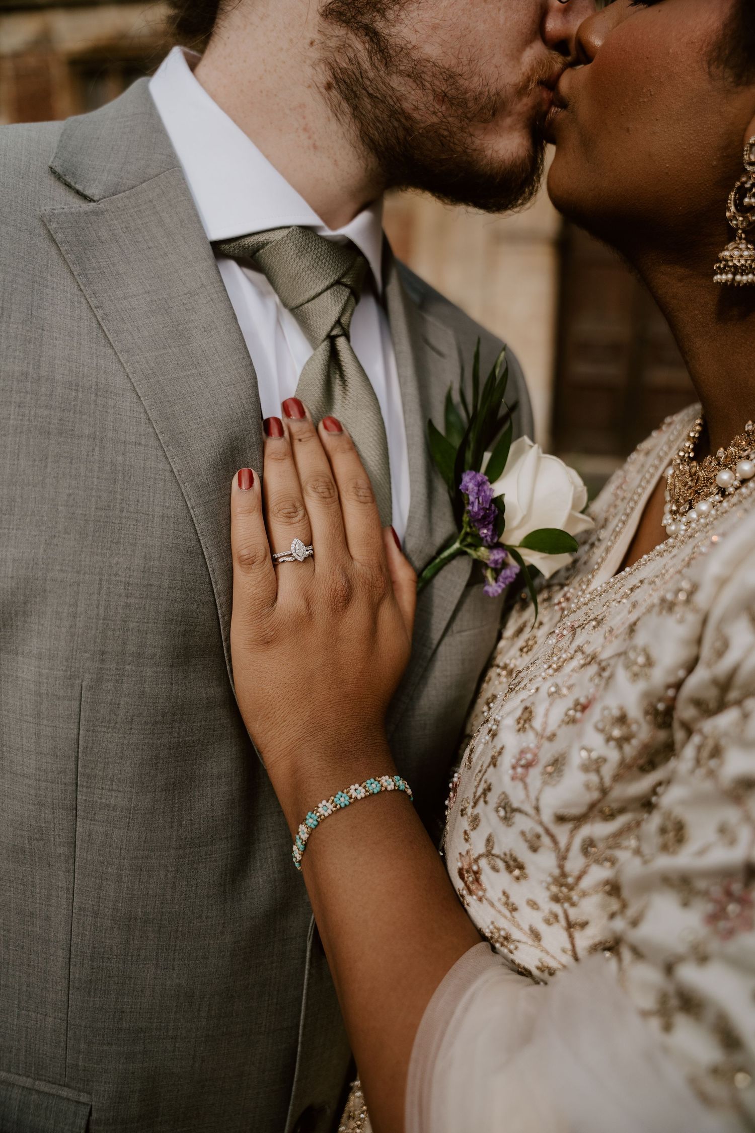 Close-up of wedding couple showing elegant jewelry and formal attire details.