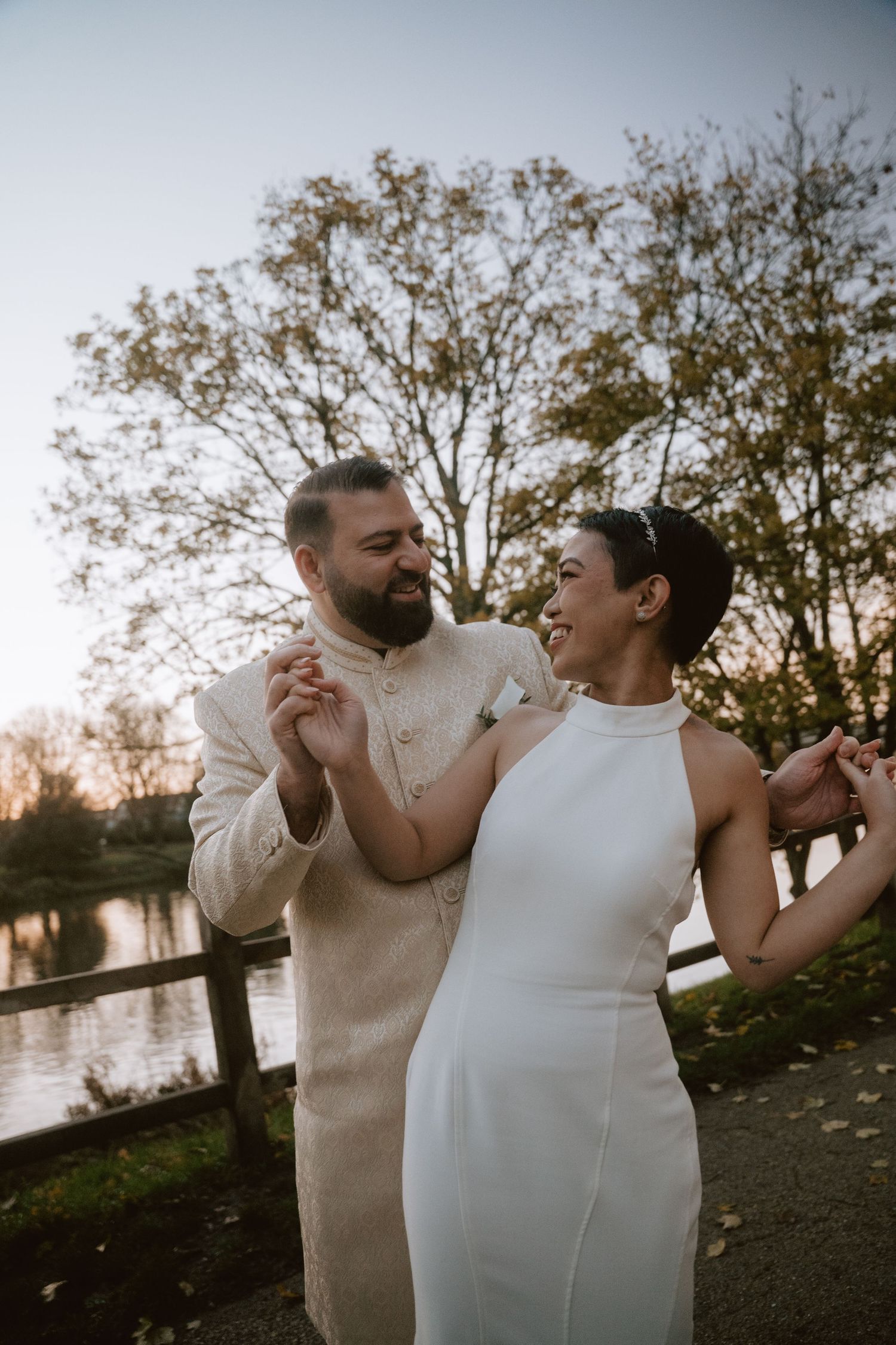 Couple shares intimate moment during sunset by a lake.