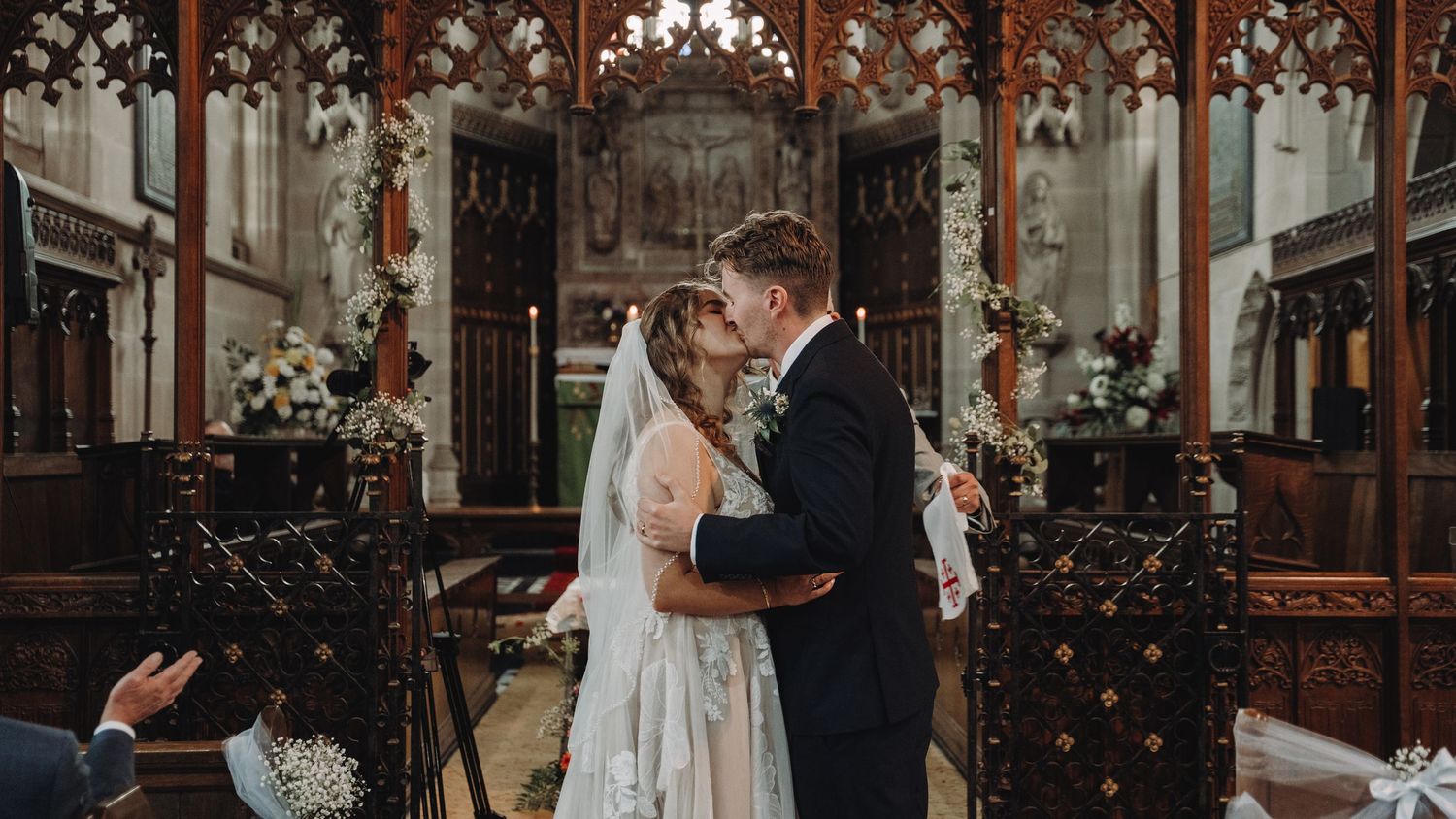Indoor wedding venue decorated with elegant floral arrangements and warm lighting.