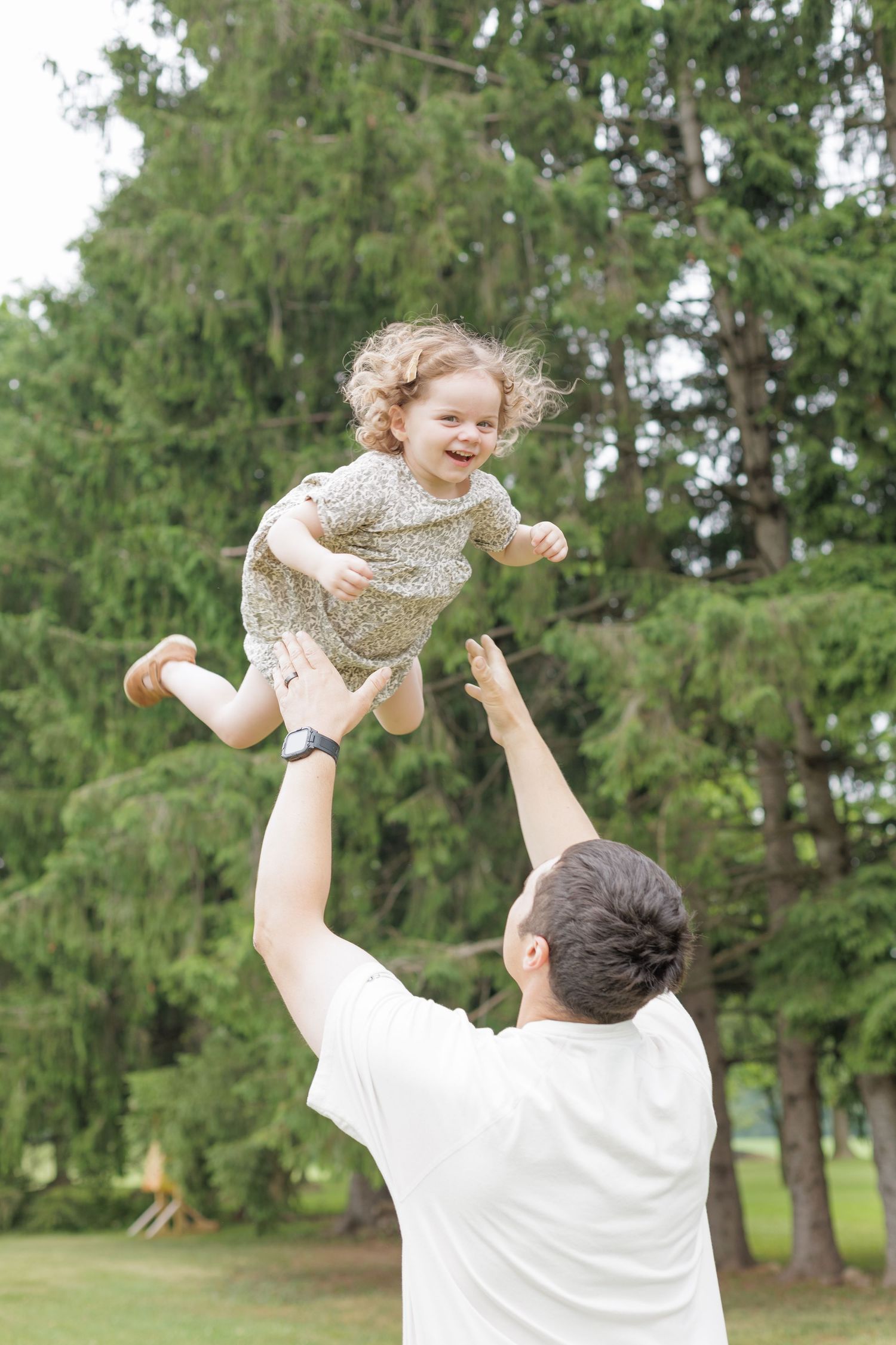 Dad playing with daughter, throwing her into the air. Lock Haven Pennsylvania photographer