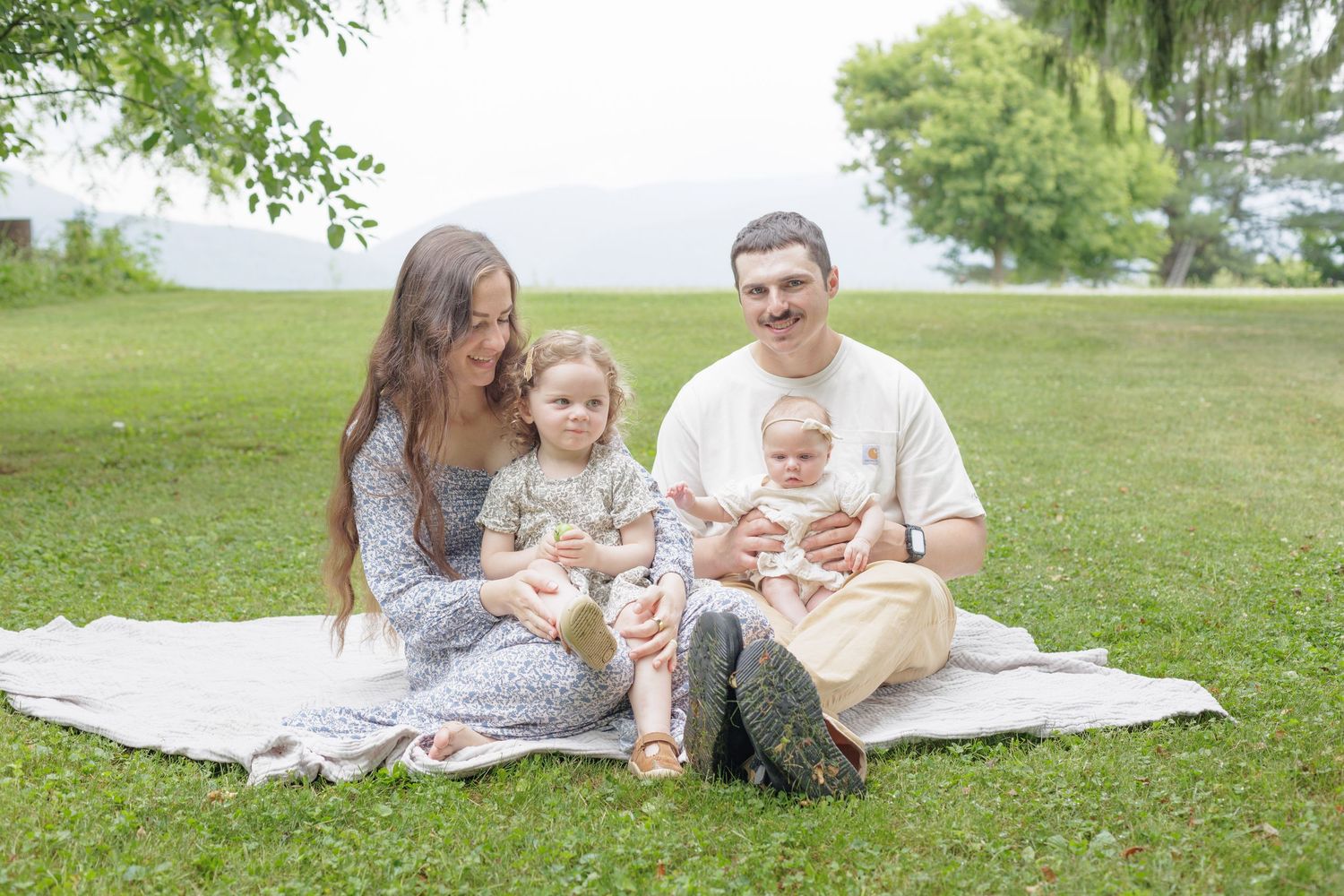 Young Family sitting in their yard in front of the mountains. Family Lifestyle Lock Haven Pennsylvania Photographer