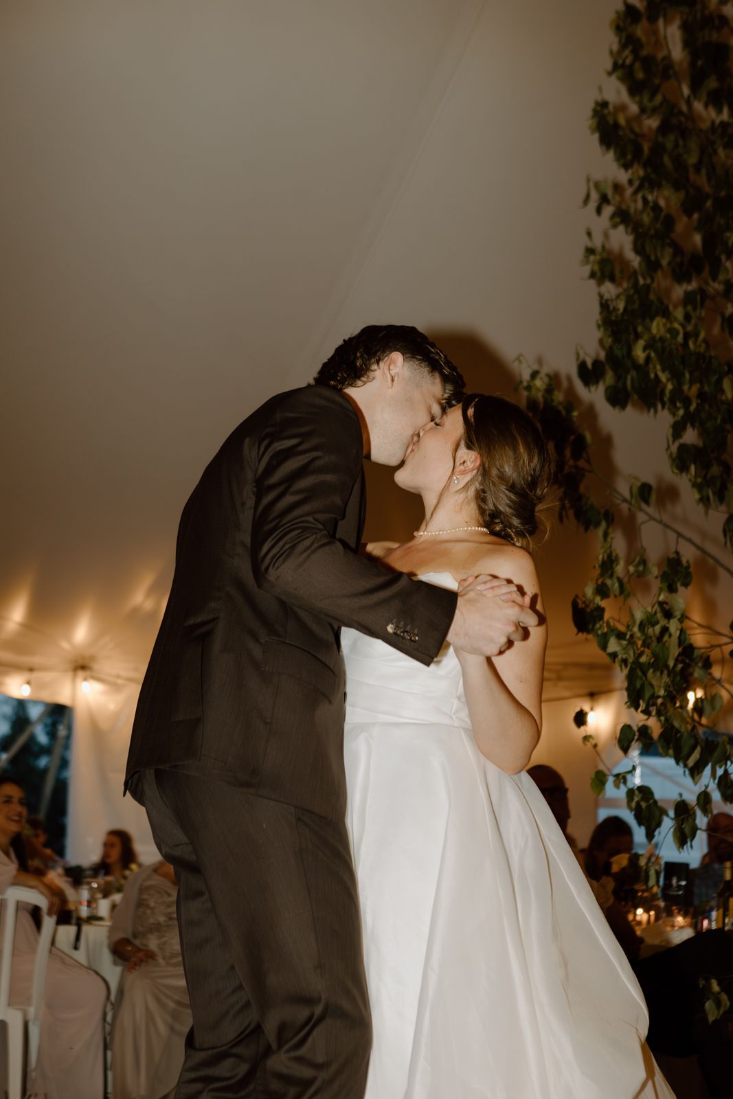 A bride and groom kissing during their first dance.