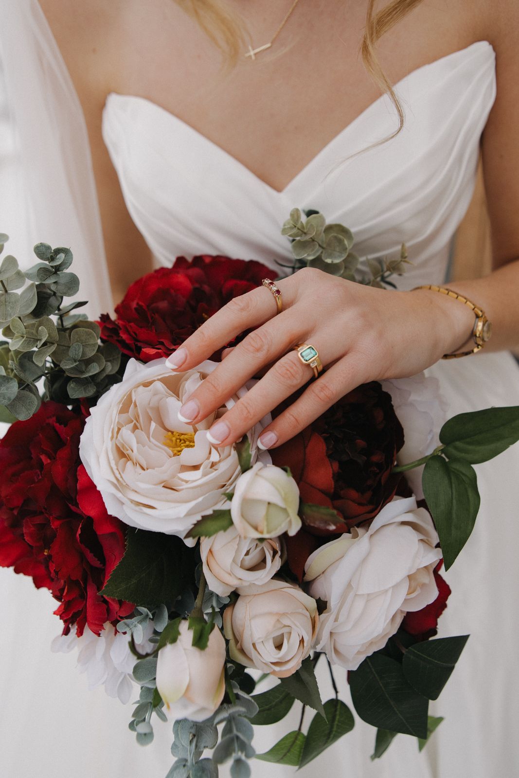 A detail photo of a bride's wedding ring over the flowers in her bouquet.