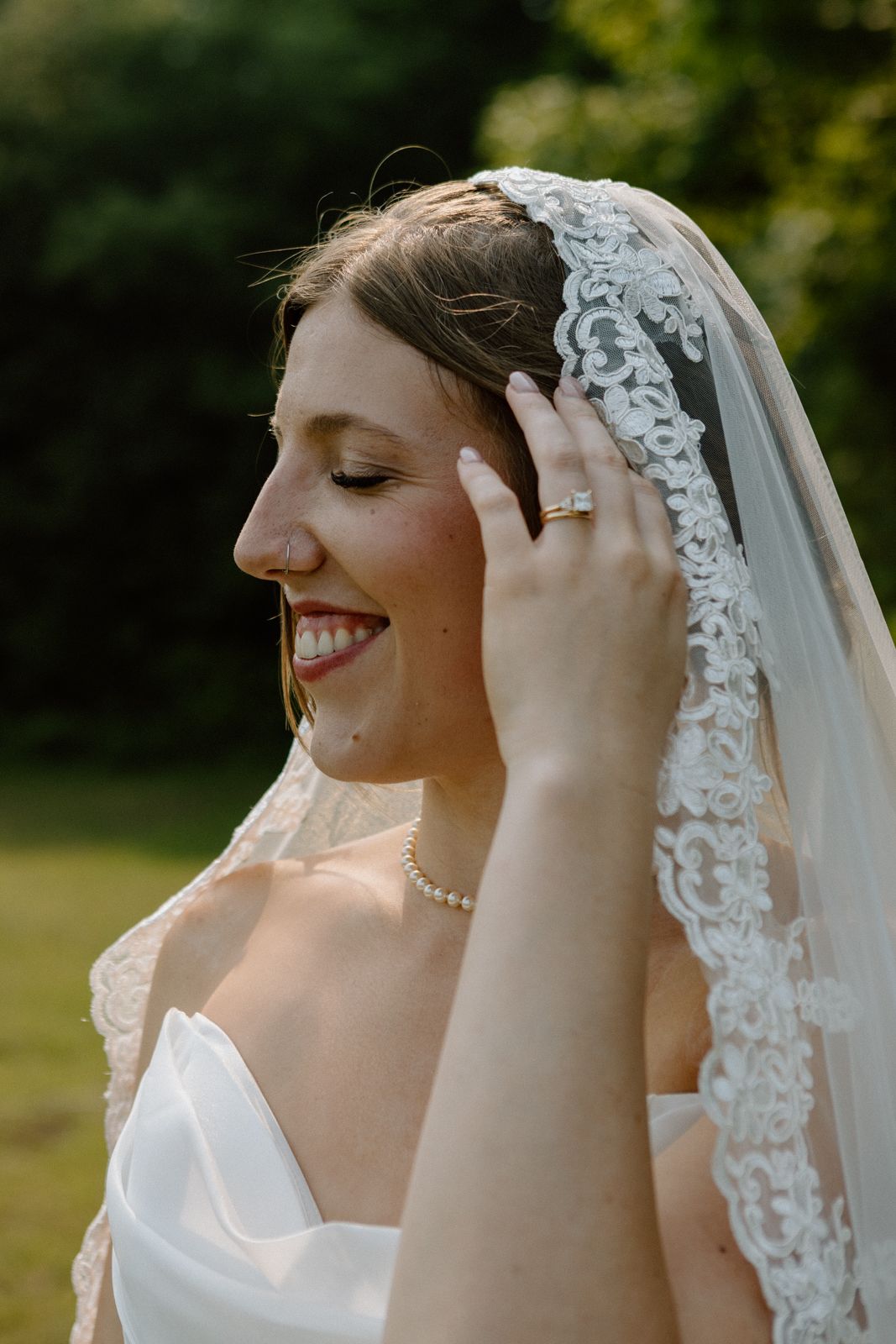 A candid image of a bride tucking her hair behind her ear.