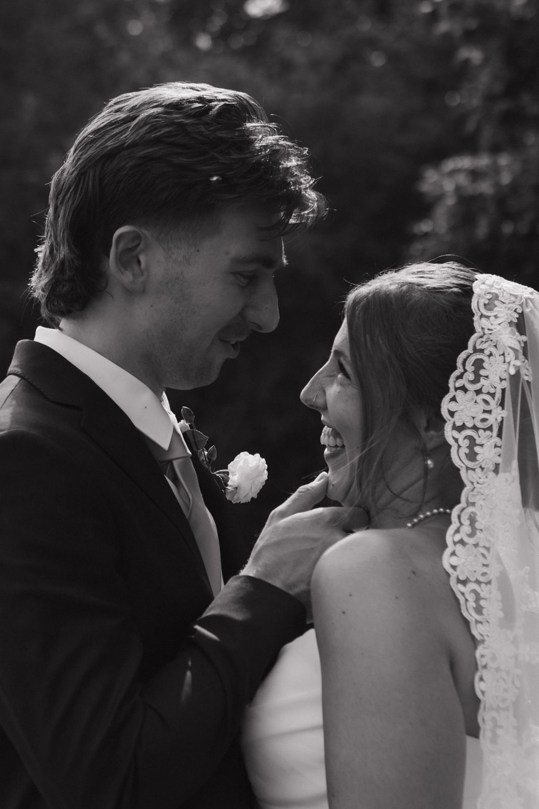 A close up of a bride and groom's faces as they look at each other.