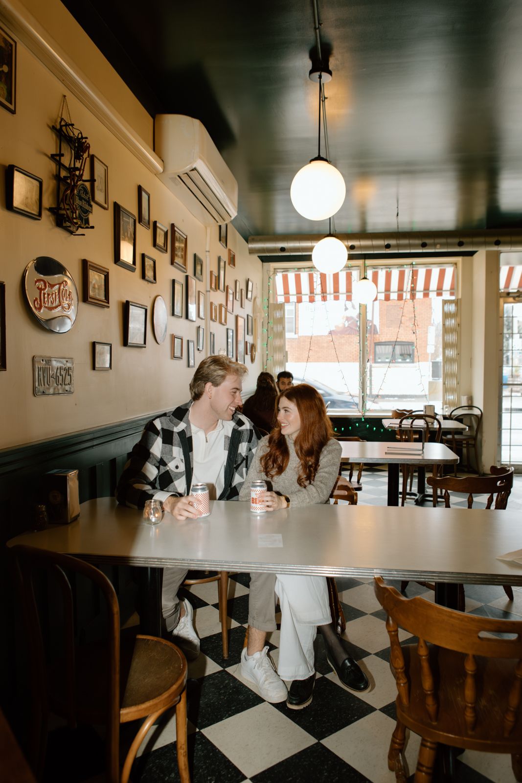 A couple sitting together at a table in a pizza parlour in Hamilton. They are looking at each other.