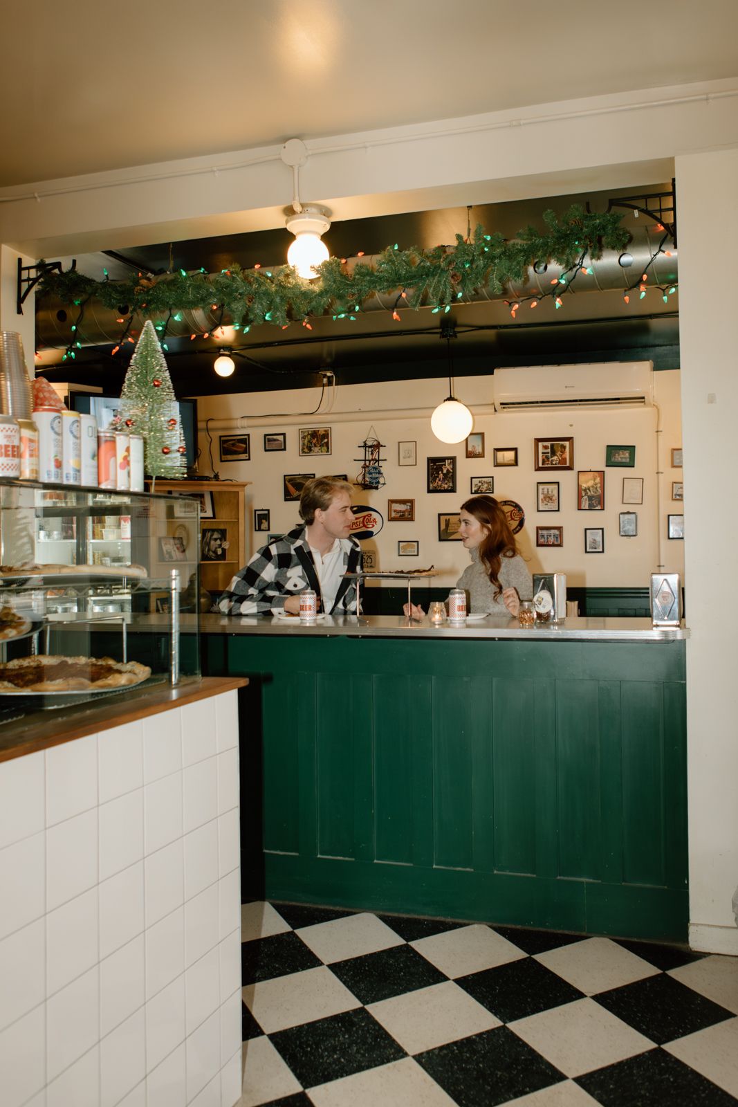 A couple sitting together at a counter in a vintage pizza parlour in Hamilton.