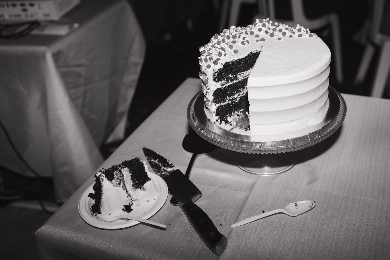 Black and white detail shot of a wedding cake that has been cut.