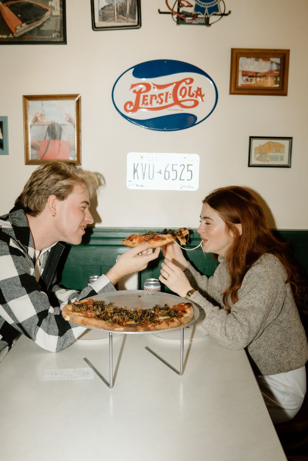 A man feeding pizza to a woman.