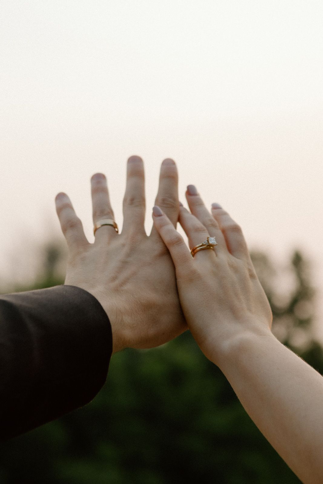A detail shot of the bride and groom's hands, focusing on their wedding bands.