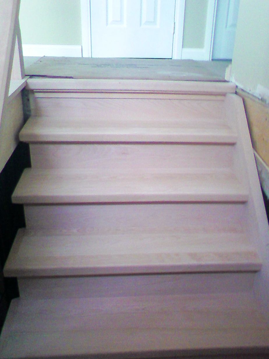 Close-up of newly installed light oak hardwood stair treads and risers.