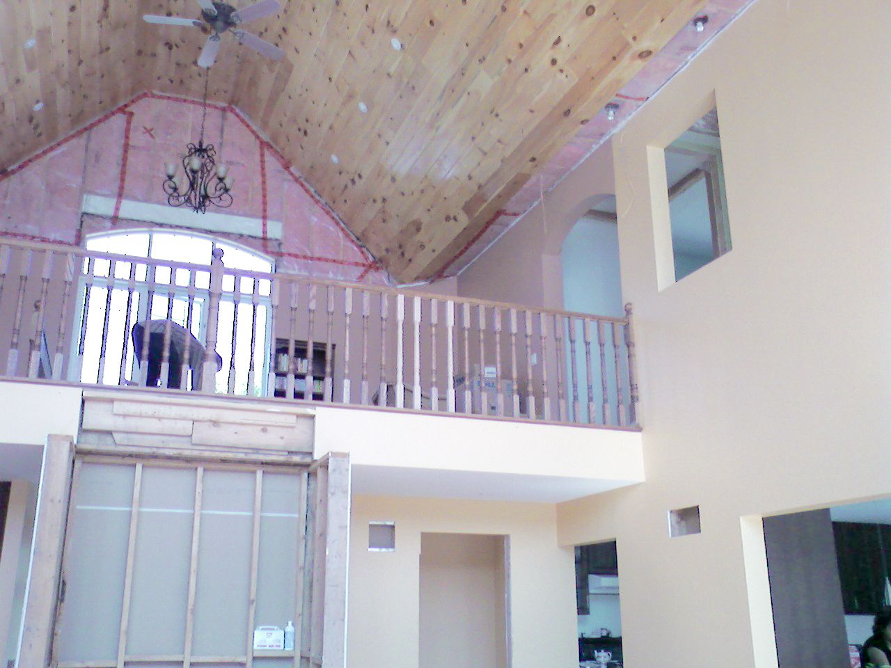 Interior view of a two-story home's upper balcony railing during renovation.