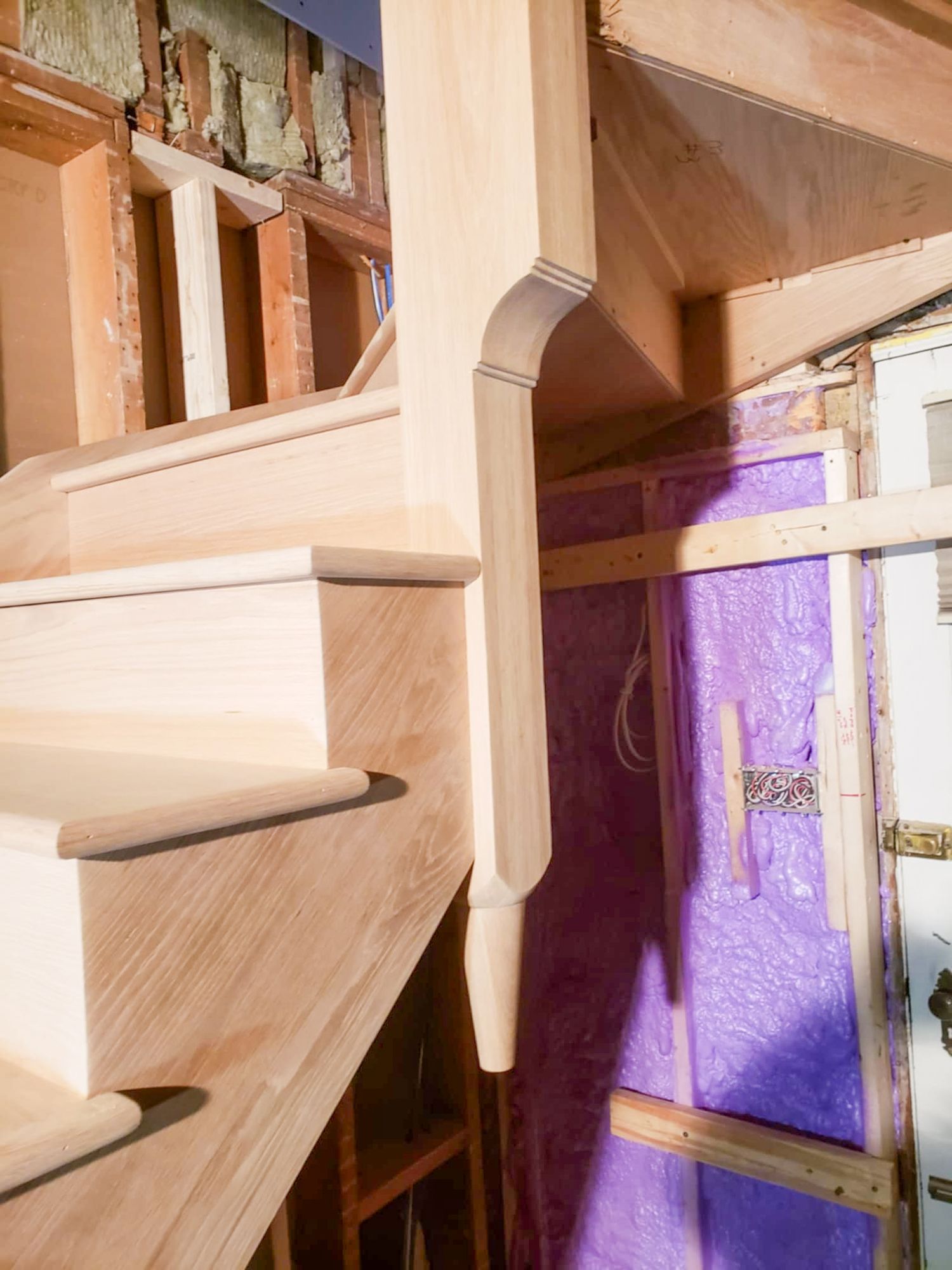 Close-up of unfinished oak stair newel post during home construction.