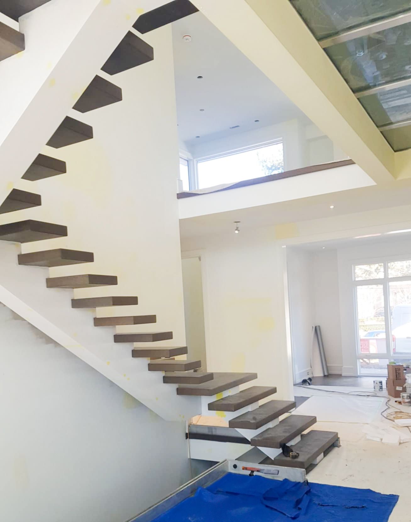Moden Mono staircase with dark wood treads in a luxury home under construction.