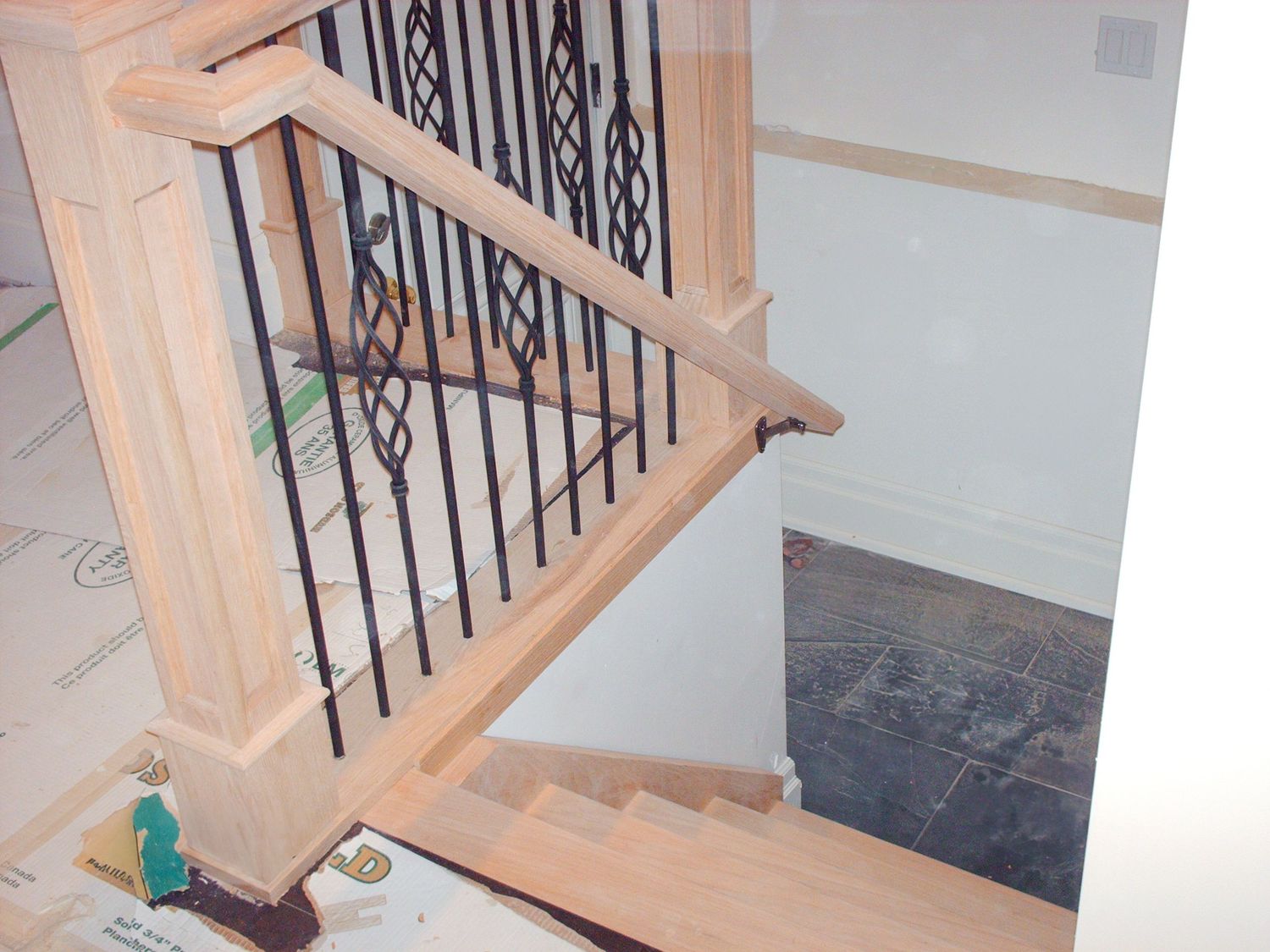 Light wood staircase with metal  basket spindles on stairs under construction.