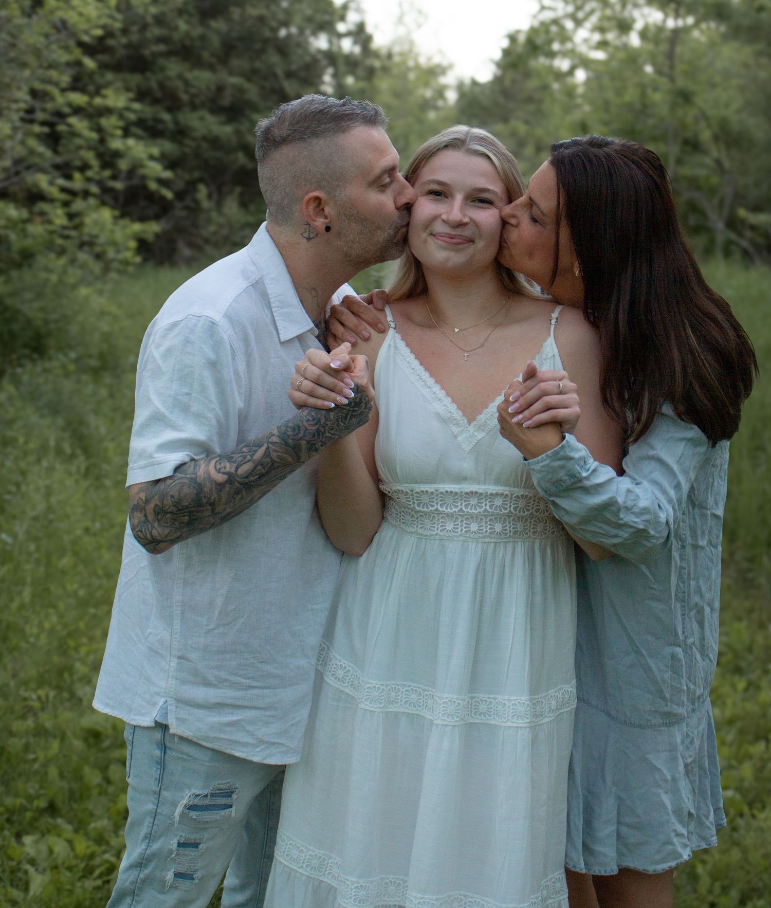 Family smiling and embracing during a family + grad photography session.