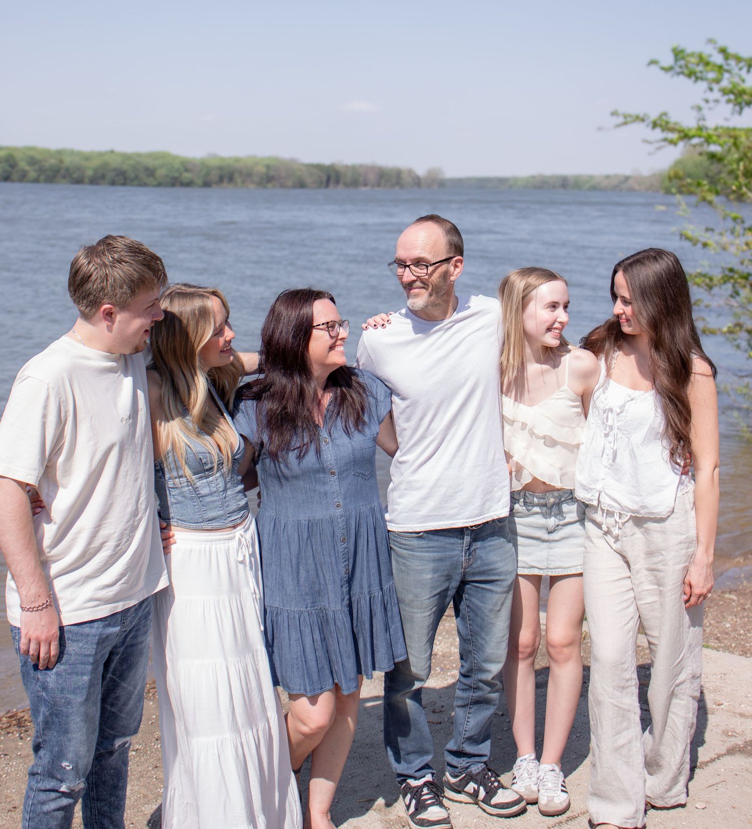 Family laughing together during an outdoor family photoshoot session by the water.