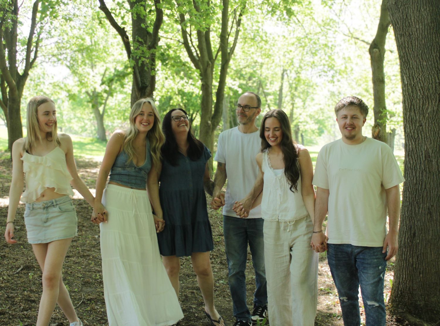 Family walking and laughing together through the trees for some beautiful candid shots.