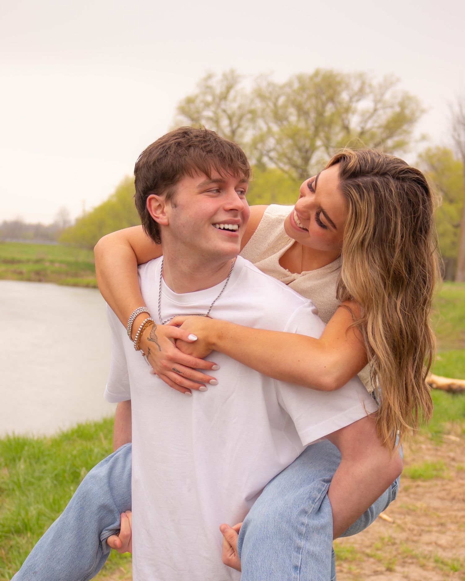 Couple posing, gazing into each others eyes, at outdoor photography session in a field.
