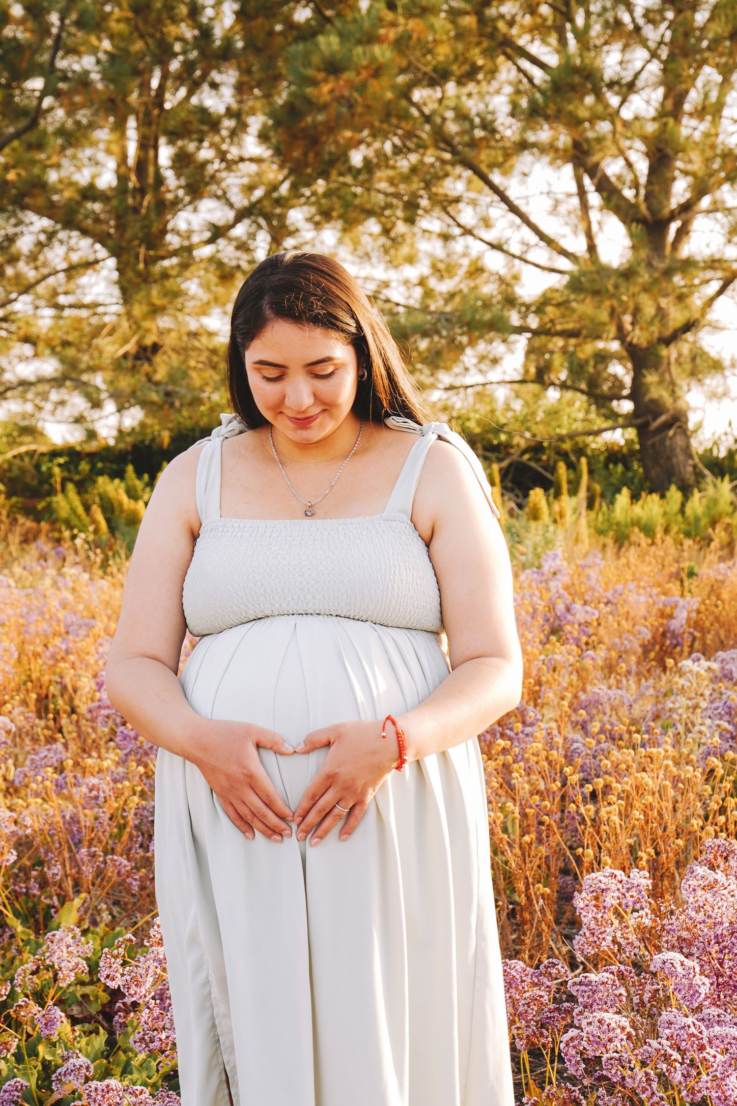 A series of photos showing someone in a white dress standing among purple wildflowers at golden hour.