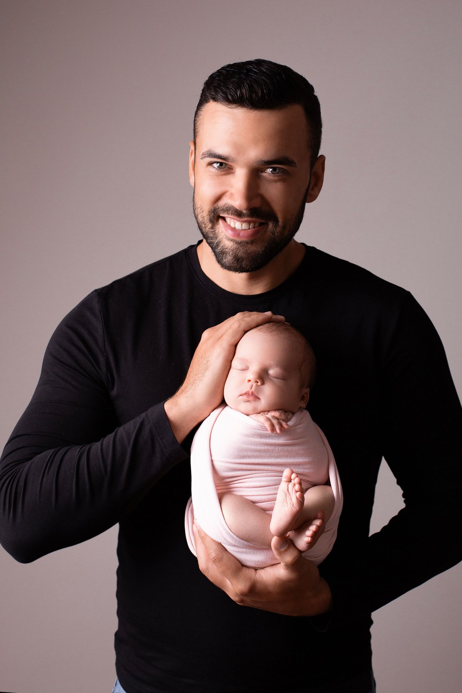 Jaundzimušo fotosesija Rīgā studijā, gulošs mazulis maigā gaismā.