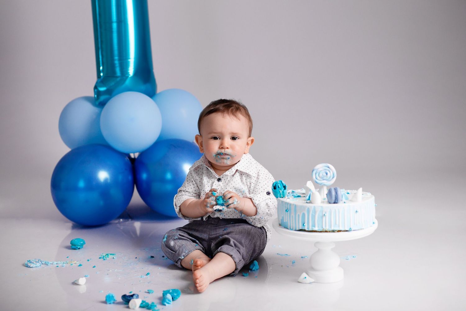 1 gada fotosesija ar kūku Rīgā, bērns ēd torti studijā.
Cake smash fotosesija Rīgā.