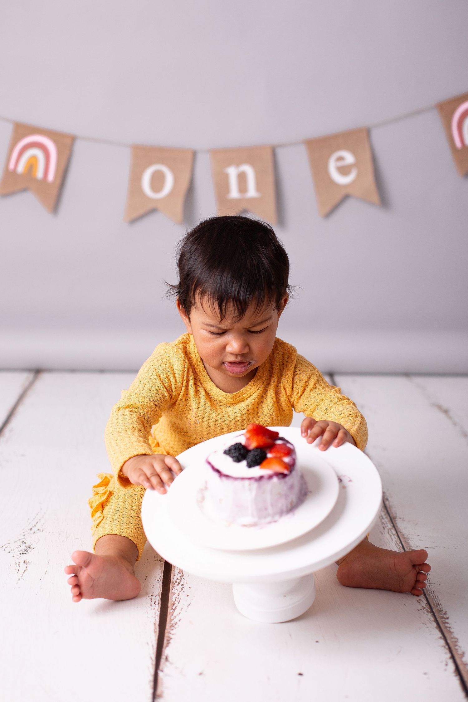 1 gada fotosesija ar kūku Rīgā, bērns ēd torti studijā.
Cake smash fotosesija Rīgā.