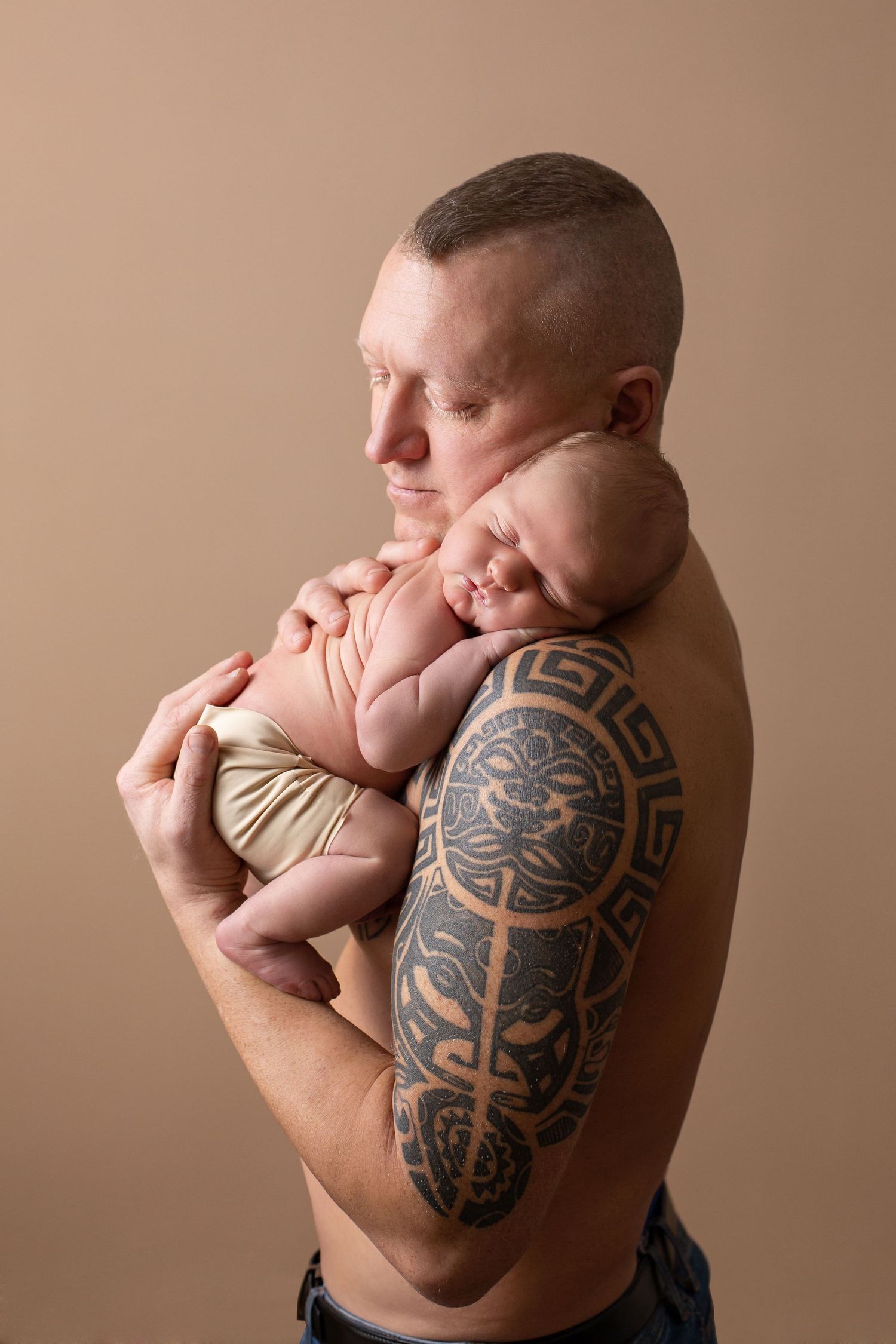Jaundzimušo fotosesija Rīgā studijā, gulošs mazulis maigā gaismā.