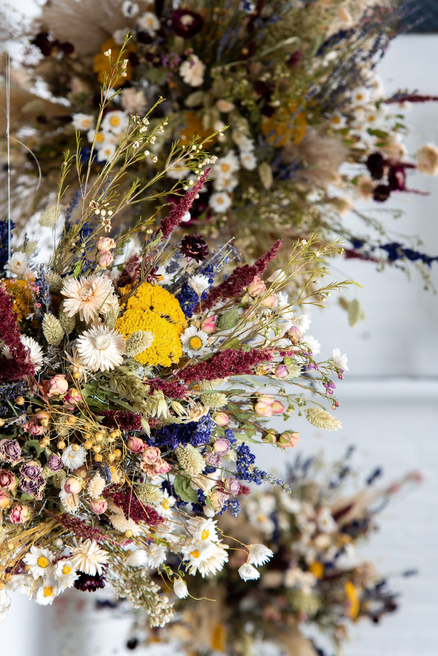 Colorful dried flower arrangement featuring yellow, pink, and white blooms in a rustic bouquet.