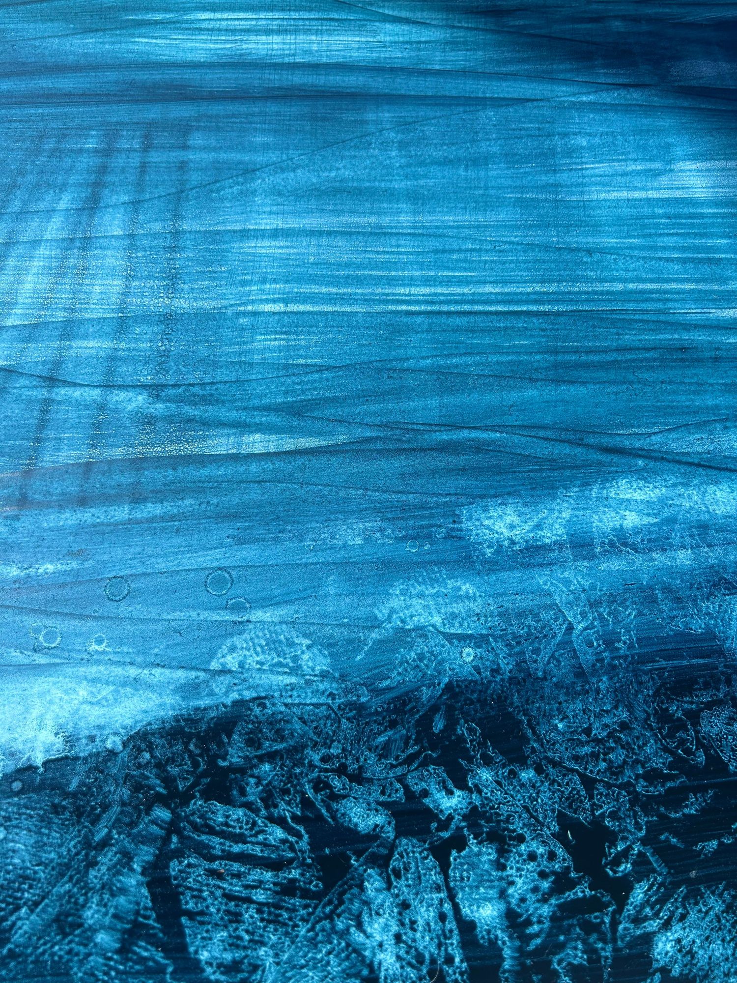 Abstract blue ocean artwork with textured waves and brushstrokes in deep teal tones.