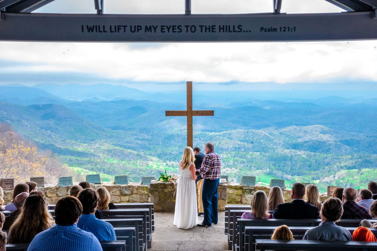 Outdoor mountain wedding ceremony at Pretty Place chapel with cross.