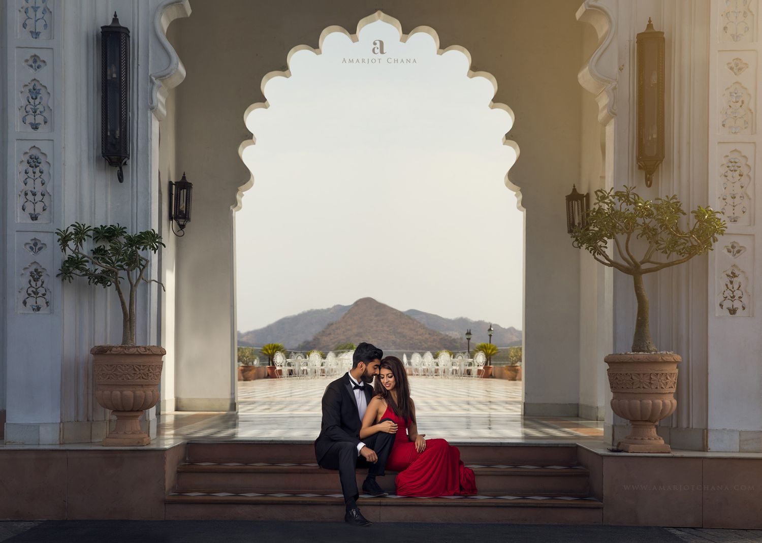 Prash and Amee pre-wedding shoot – intimate couple moment under grand white Mughal arch in red and black formal attire, destination Indian w
