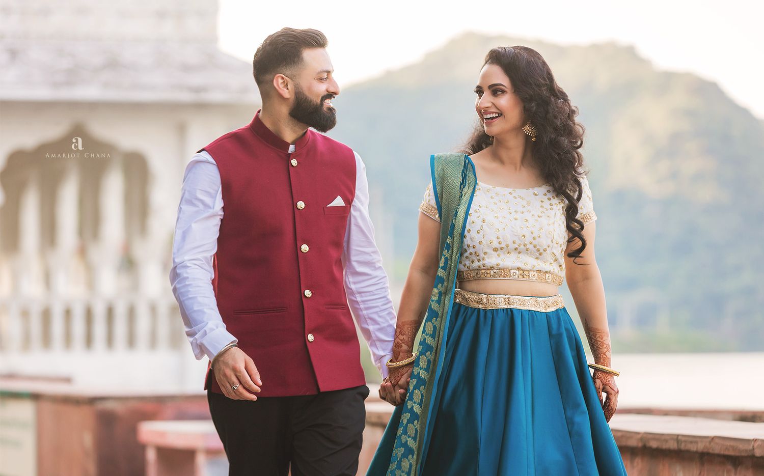 Indian couple sharing intimate kiss in dramatic ray of light streaming through window in rustic venue, cinematic Sikh wedding photography UK