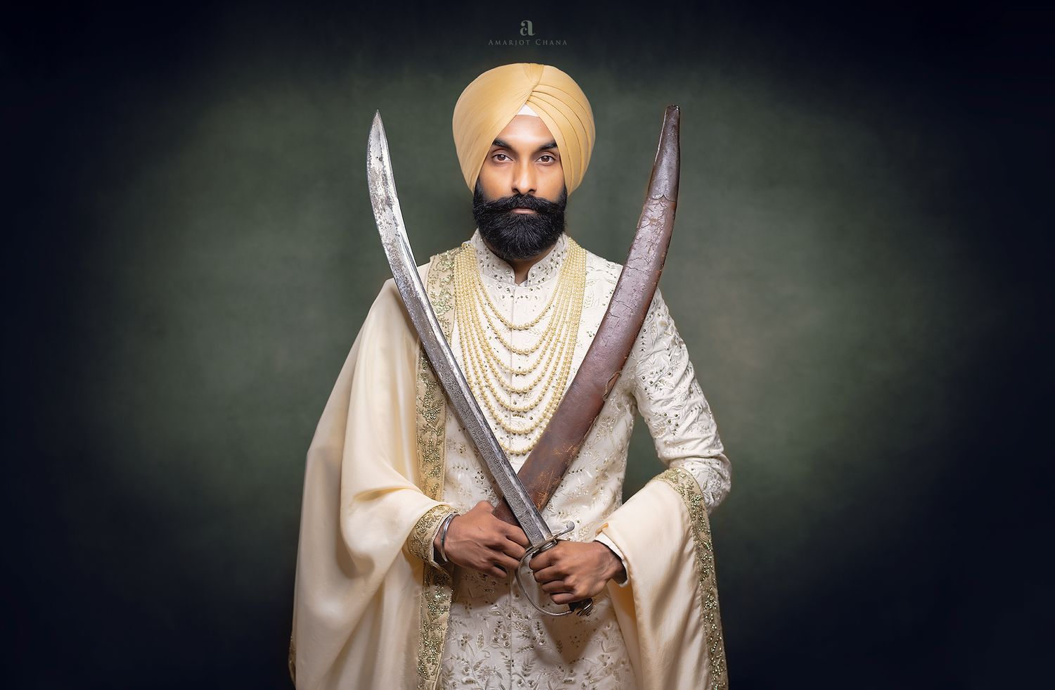 Guv and Monika Sikh wedding, Sikh groom in white sherwani holding two ceremonial kirpans, wearing pearl mala and golden turban, Sikh wedding