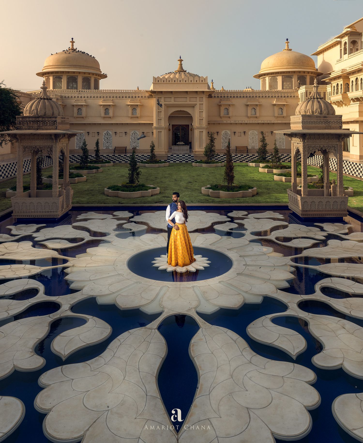 Prash and Amee pre-wedding portraits – couple reflected in still pool before grand arched Rajasthani heritage palace entrance, destination I