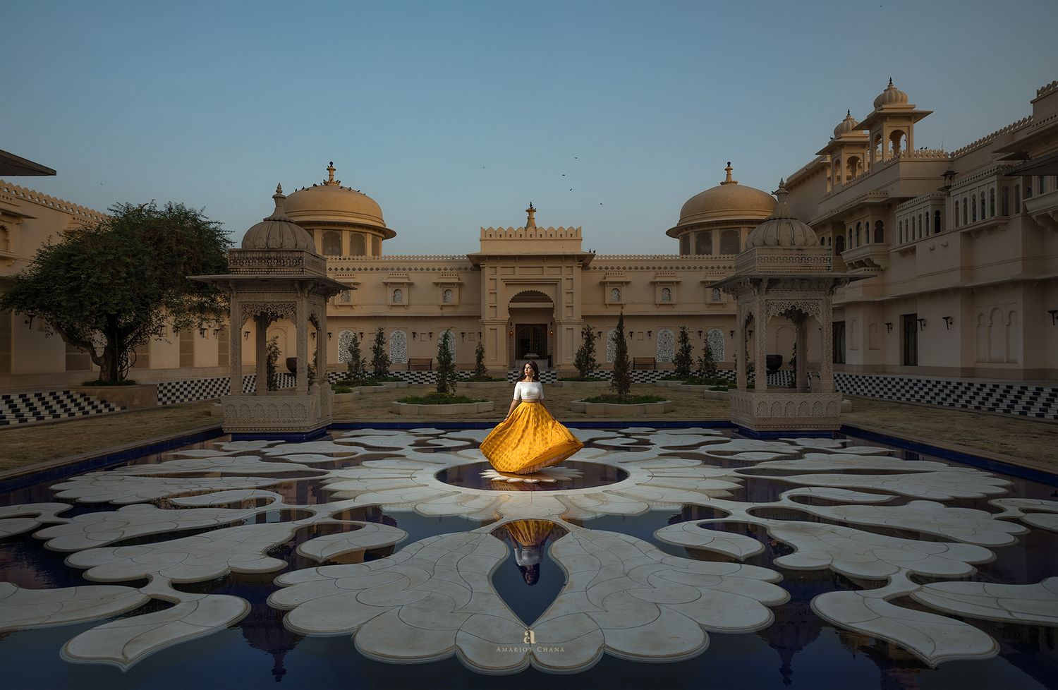 Prash and Amee pre-wedding portraits – woman in vibrant yellow lehenga twirling in grand ornate Rajasthani palace courtyard, destination